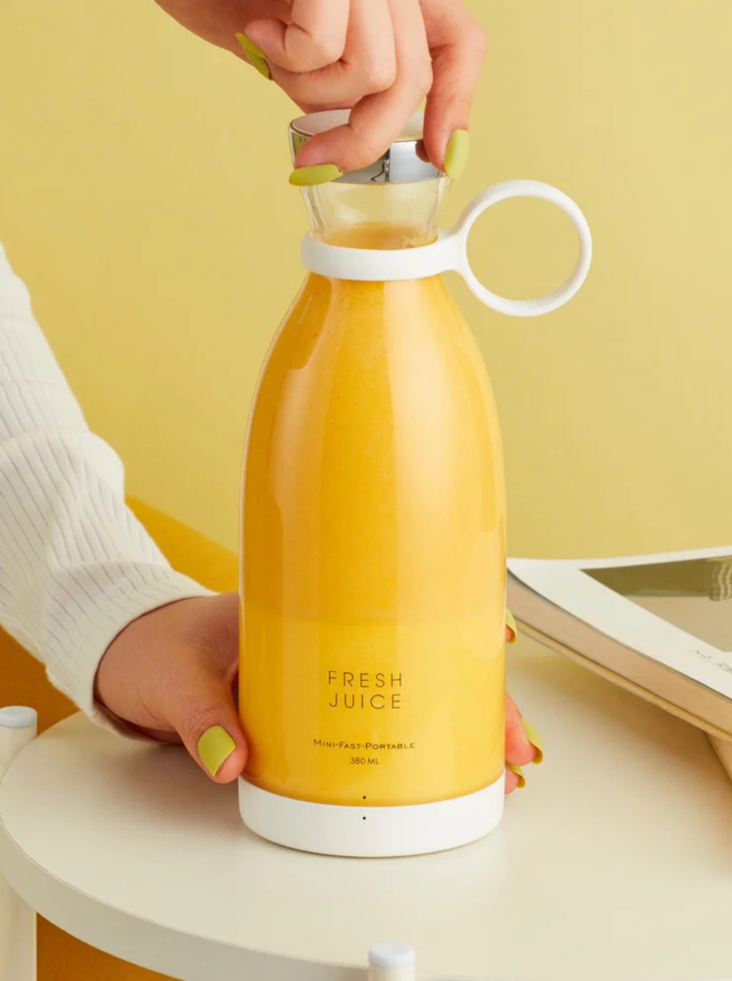 Mains de femme tenant le blender Fresh Juice rempli d'un smoothie à la mangue